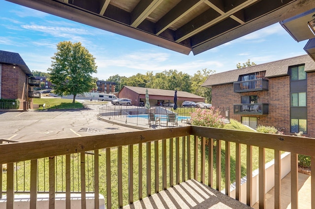 wooden terrace with a community pool and a lawn