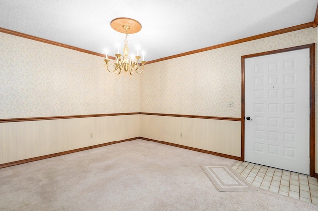 spare room featuring light carpet, crown molding, and a chandelier