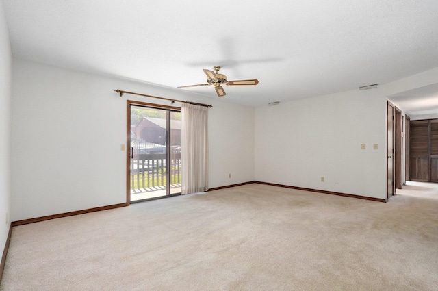 spare room with ceiling fan and light colored carpet