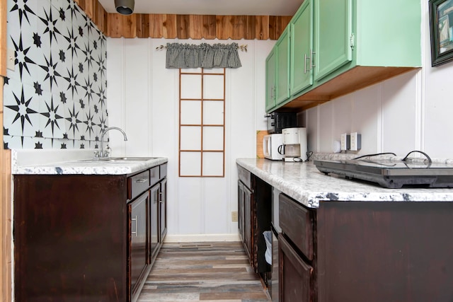 kitchen with backsplash, green cabinetry, dark hardwood / wood-style floors, and sink