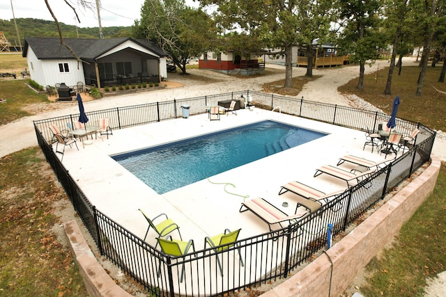 view of pool with a sunroom and a patio area