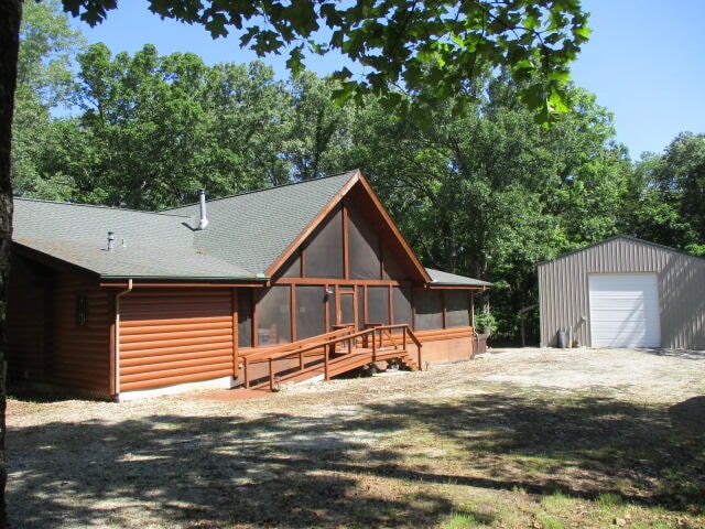 view of front of home with a garage and an outbuilding