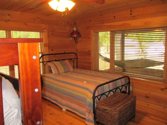 bedroom featuring wood-type flooring, wood walls, and wooden ceiling