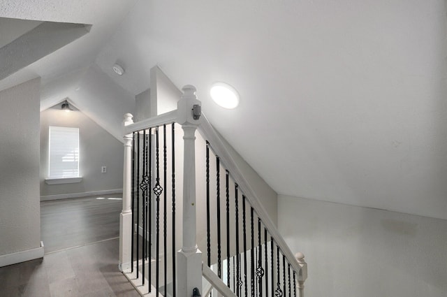 staircase with lofted ceiling and hardwood / wood-style floors