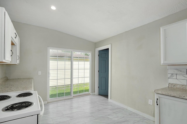 kitchen with lofted ceiling, white electric range oven, tasteful backsplash, and white cabinetry