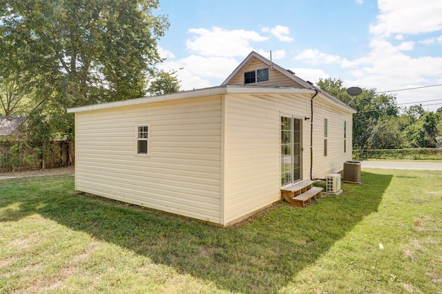 view of side of home featuring central air condition unit and a lawn