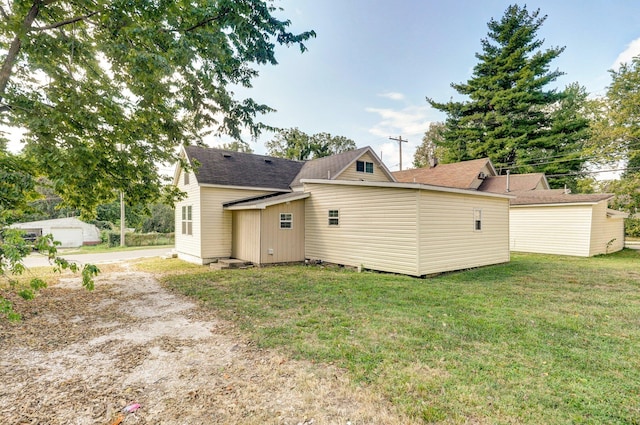 back of house with a lawn and an outbuilding