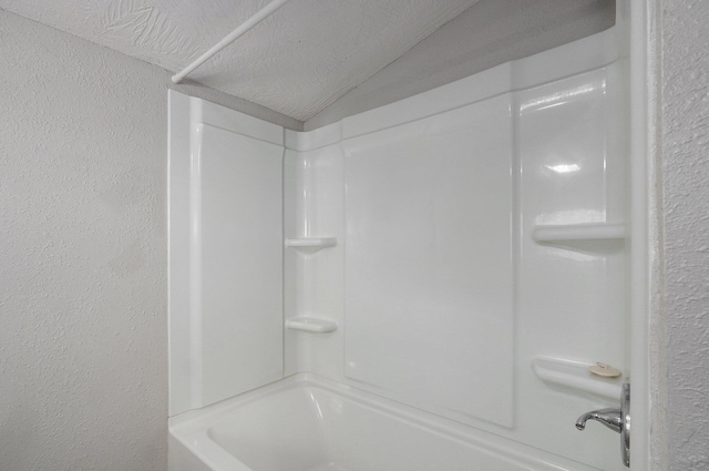 bathroom featuring tub / shower combination and a textured ceiling