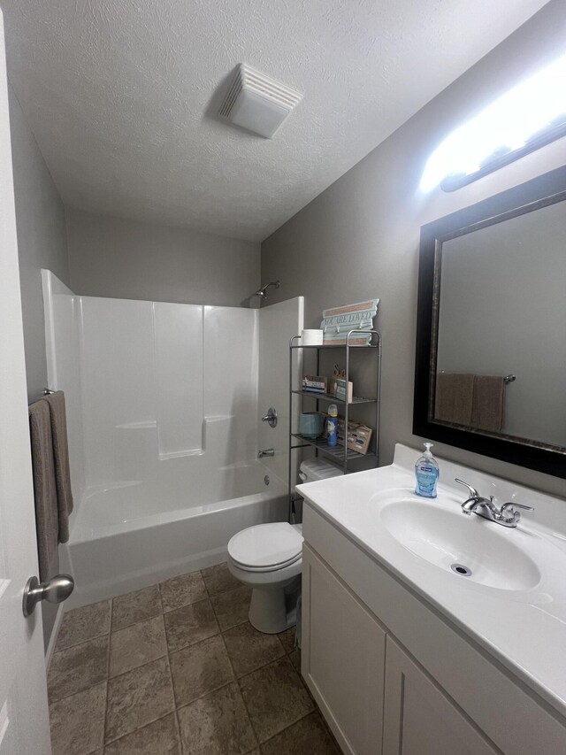 full bathroom with vanity, toilet, shower / washtub combination, and a textured ceiling