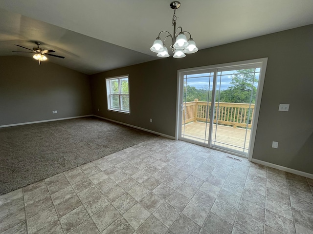 interior space featuring lofted ceiling, plenty of natural light, ceiling fan with notable chandelier, and light carpet