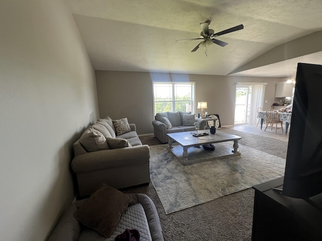 living room featuring ceiling fan, carpet floors, and vaulted ceiling