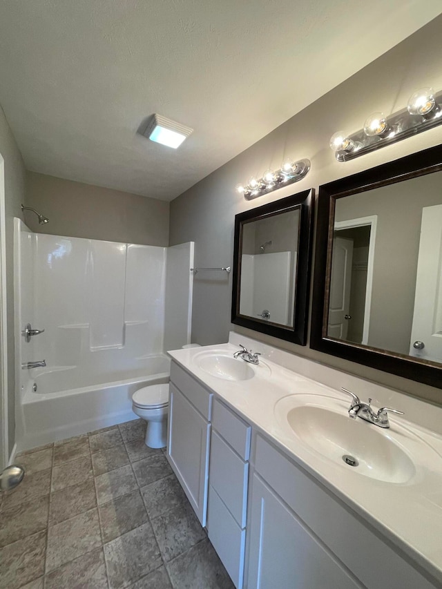 full bathroom featuring tub / shower combination, vanity, toilet, and a textured ceiling