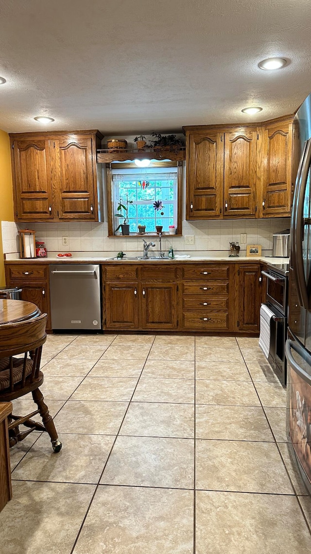 kitchen featuring a textured ceiling, appliances with stainless steel finishes, and light tile patterned floors