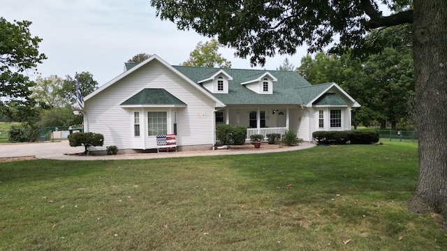 cape cod home with a front lawn and covered porch