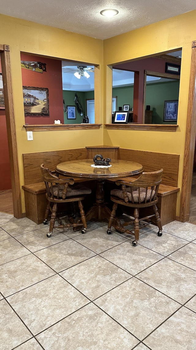 tiled dining space featuring a textured ceiling