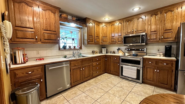 kitchen featuring stainless steel appliances, light tile patterned flooring, sink, and decorative backsplash