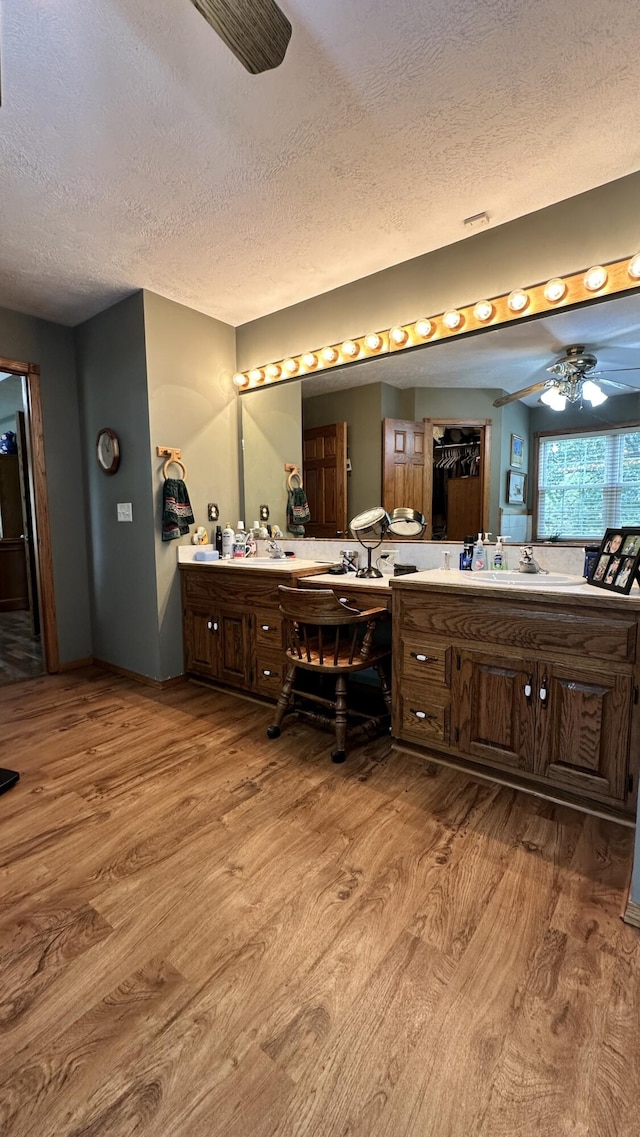 bathroom with hardwood / wood-style floors, vanity, and a textured ceiling