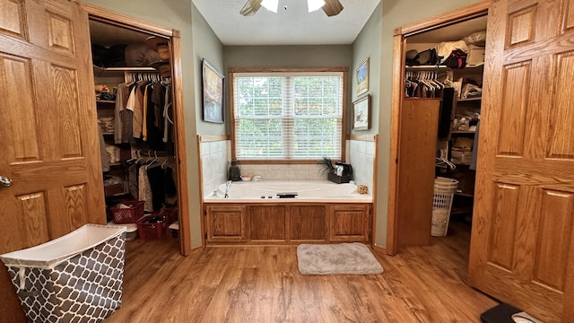 bathroom featuring a tub to relax in, ceiling fan, and hardwood / wood-style floors