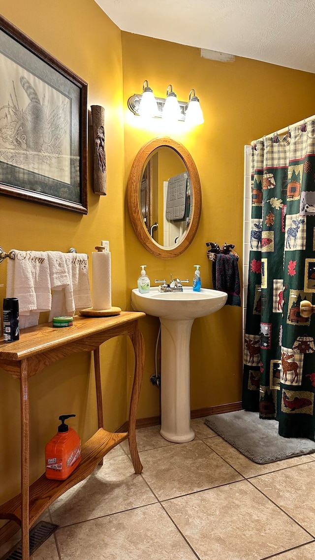 bathroom with a textured ceiling and tile patterned flooring