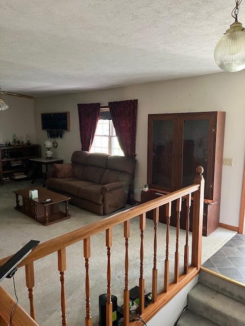 living area with a textured ceiling and stairs