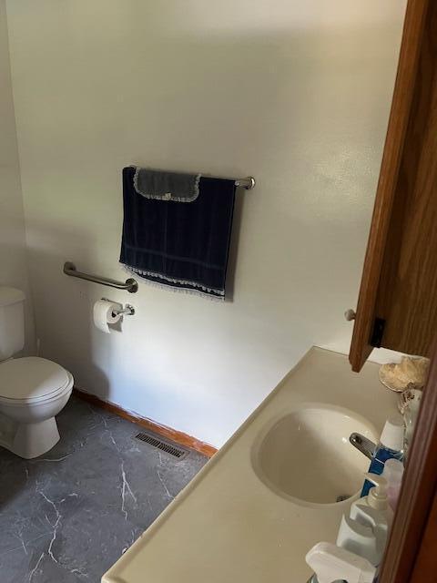 bathroom featuring visible vents, a sink, and toilet