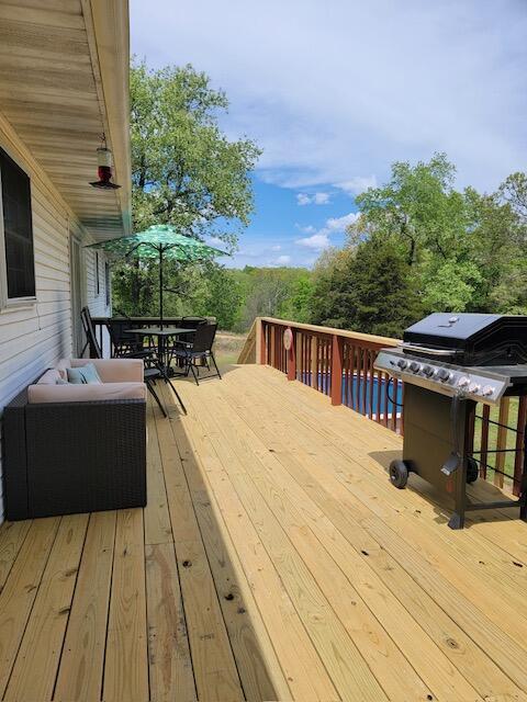 wooden deck featuring outdoor dining area and grilling area