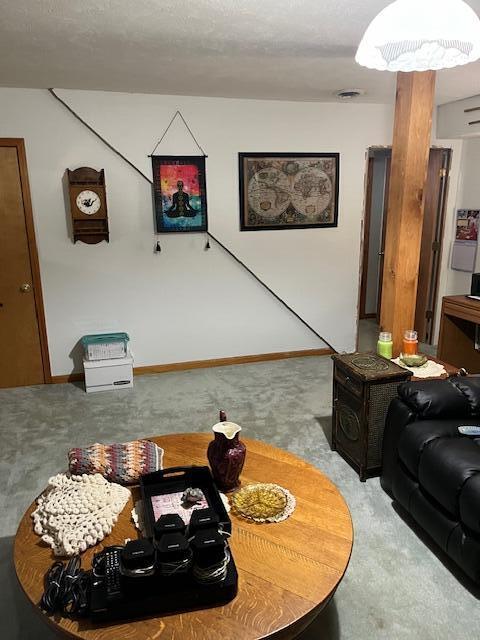 living area with baseboards, visible vents, and carpet