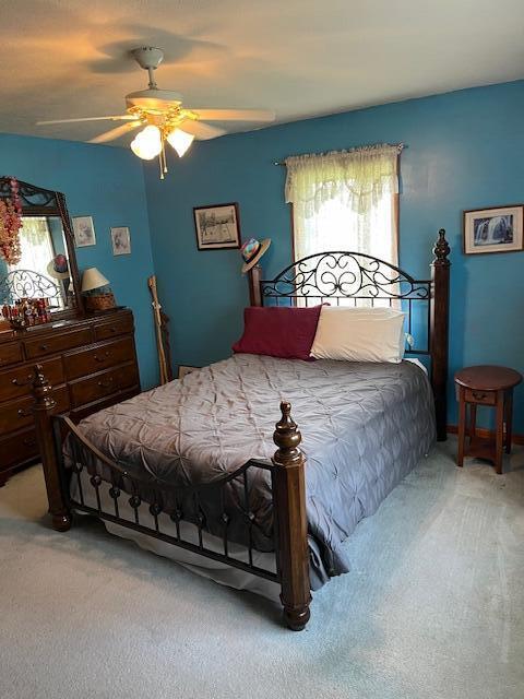 bedroom featuring light colored carpet and ceiling fan