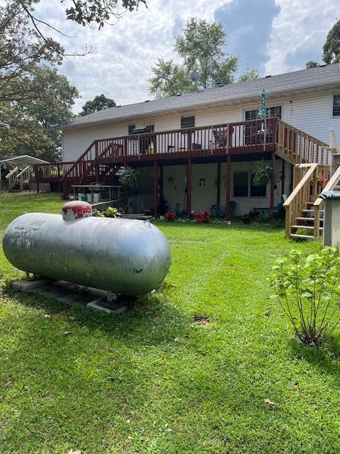 back of house with a wooden deck, a yard, and stairs
