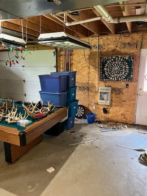 basement featuring a wood stove and heating unit