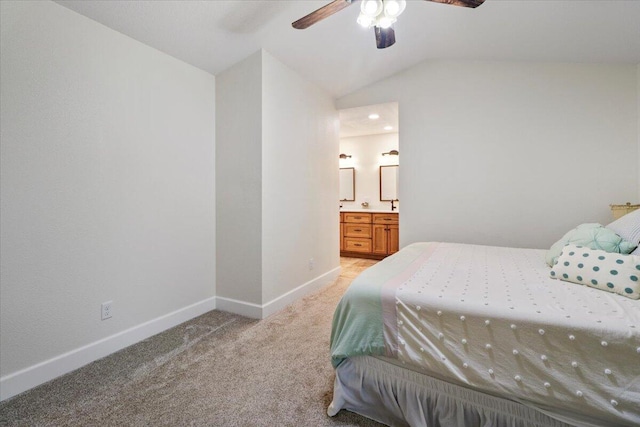 carpeted bedroom featuring vaulted ceiling, ensuite bathroom, and ceiling fan