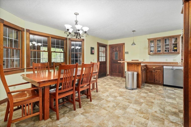 dining area featuring an inviting chandelier and a textured ceiling