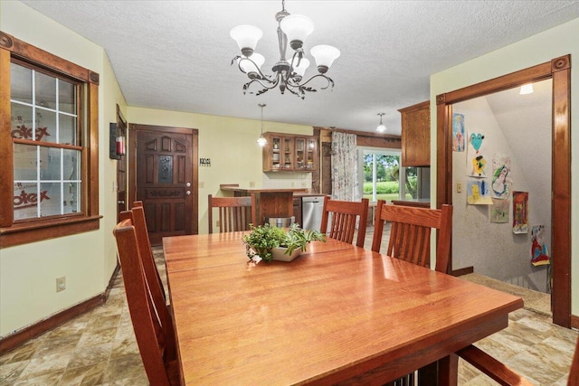 dining space featuring a notable chandelier and a textured ceiling