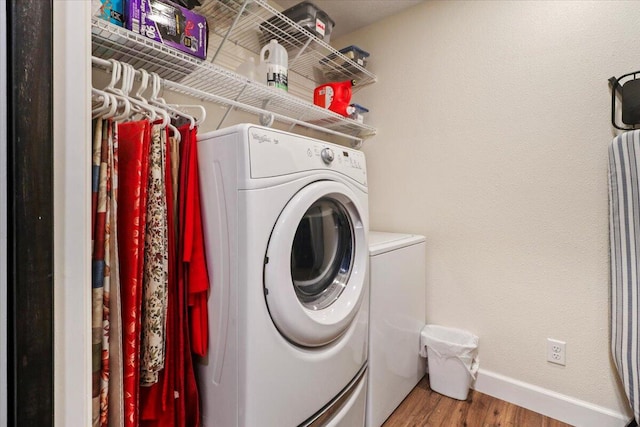 laundry area with washer and dryer and hardwood / wood-style floors