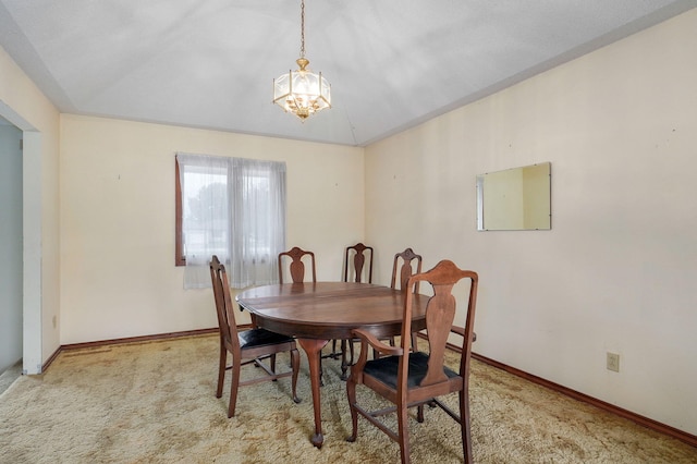 dining space with light carpet, a notable chandelier, and lofted ceiling