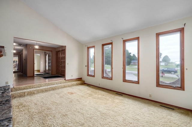 unfurnished living room featuring carpet flooring and high vaulted ceiling