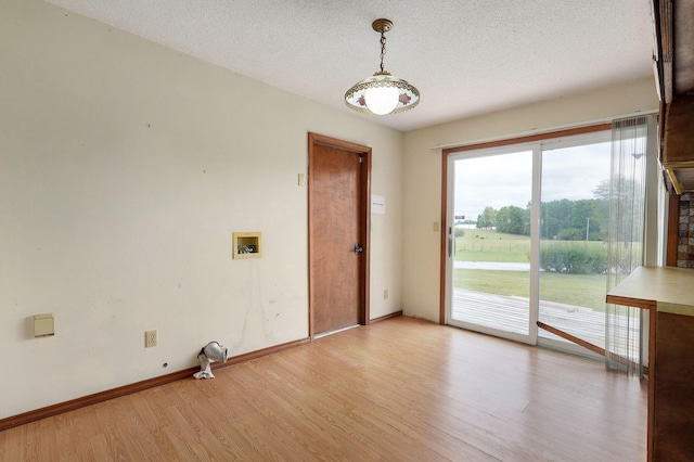 spare room featuring a textured ceiling and light wood-type flooring