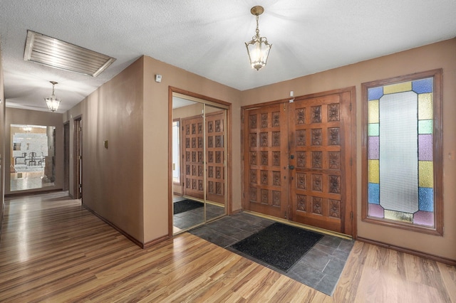 foyer entrance with plenty of natural light, hardwood / wood-style floors, and a textured ceiling