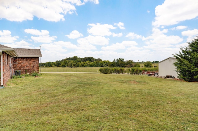 view of yard featuring a rural view and a shed