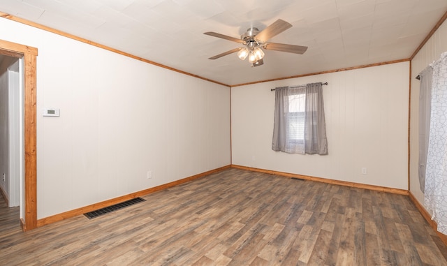 empty room featuring ceiling fan, crown molding, and dark wood-type flooring