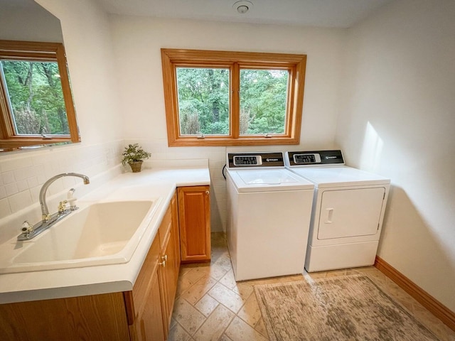 6643 E Turner Springs Dr, Springfield, MO 65809 - clothes washing area featuring washing machine and dryer, a sink, cabinet space, and a healthy amount of sunlight
