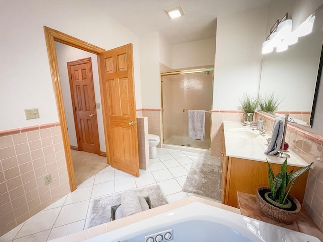 6643 E Turner Springs Dr, Springfield, MO 65809 - bathroom featuring toilet, tile walls, a shower stall, and tile patterned flooring