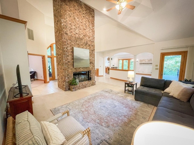 6643 E Turner Springs Dr, Springfield, MO 65809 - tiled living room featuring a fireplace, carpet flooring, a ceiling fan, high vaulted ceiling, and arched walkways