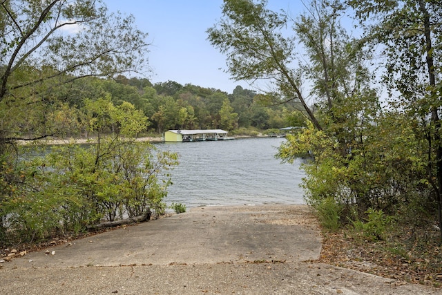 property view of water with a forest view and a boat dock