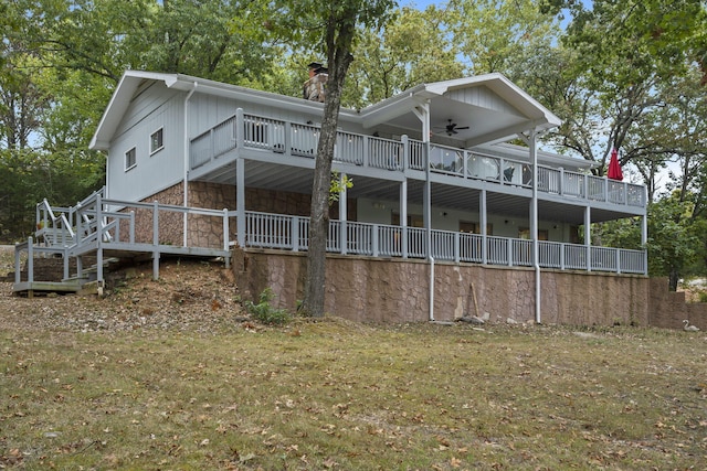 rear view of house with stone siding, ceiling fan, and a chimney