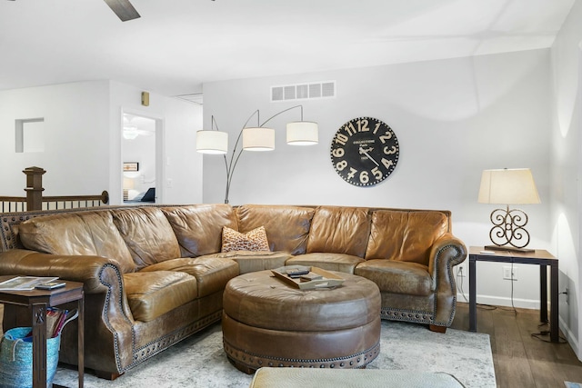 living area featuring visible vents and wood finished floors