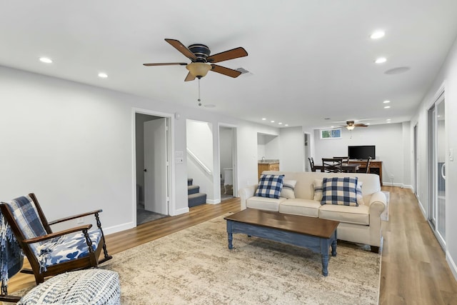 living area featuring recessed lighting, wood finished floors, stairs, and ceiling fan