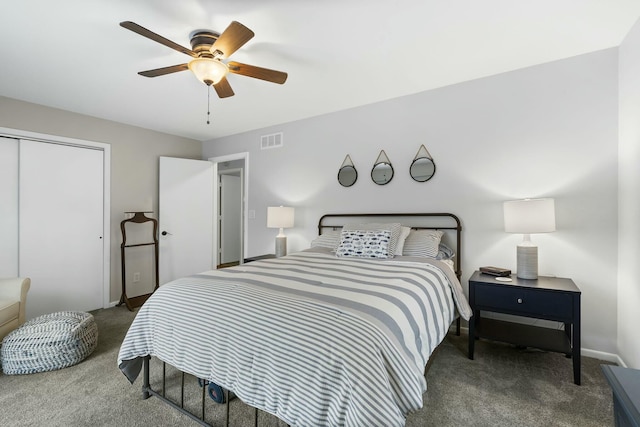 carpeted bedroom featuring a closet, visible vents, baseboards, and a ceiling fan