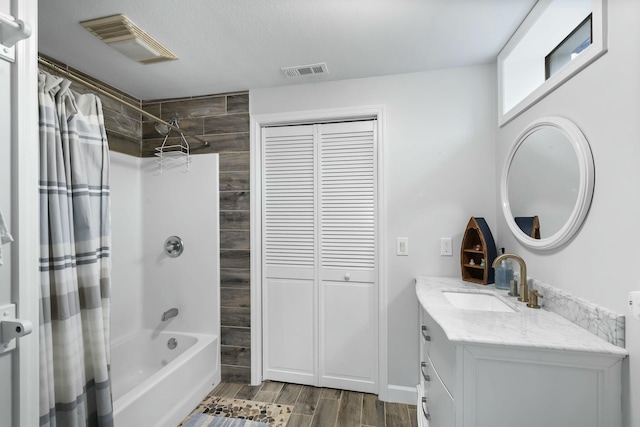 bathroom with wood-type flooring, shower / bathtub combination with curtain, and vanity