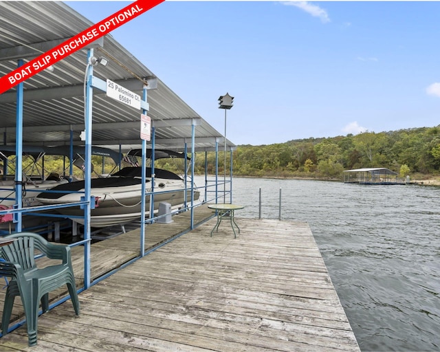 view of dock with a water view and a wooded view